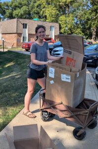 young woman using a wagon to move boxes